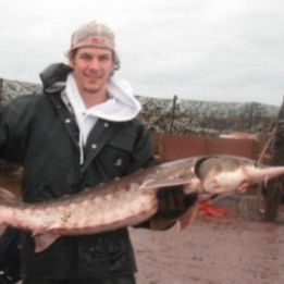 Tom, holding a sturgeon at the Five Islands Weir